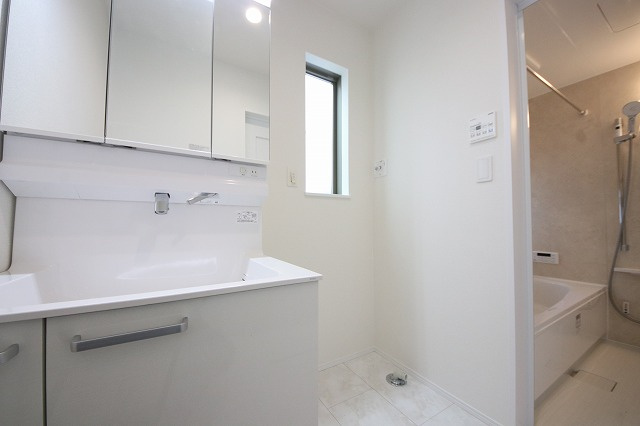 【洗面所】 | 洗濯機置き場と脱衣スペースもしっかりと確保されている洗面室、洗面コーナーは、窓から陽も差し明るく開放的な造りです。家事導線も良いので洗濯物やお湯はりもストレスフリーに毎日家事を楽しめそうです。
