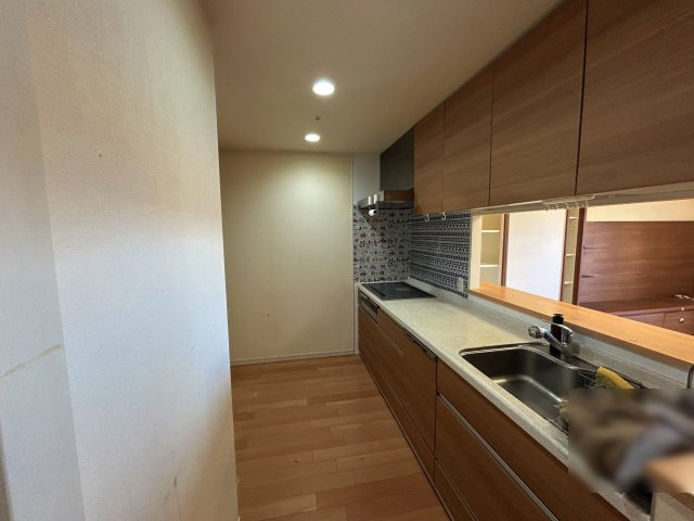 エルグレース彩都箕面D棟のキッチン|家族との会話が弾む対面式。 お料理中もリビングのご家族を見守れる、開放的なカウンターキッチンです。ゆとりの約3.7帖。 背面にカップボードを置いても余裕があり、お二人での作業もスムーズです。