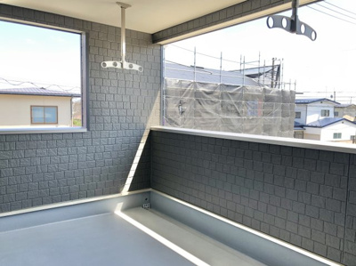 【バルコニー】 | 【新築戸建て】秋田市新屋日吉町　第2 | ※未完成につき同仕様写真
レンガ調の壁で落ち着きあるバルコニー。物干しも備わり、洗濯も快適