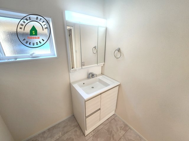 福岡市早良区飯倉3丁目第20-2棟（2号棟）の内観：施工例|毎日使うものだから清潔な空間を保ちたい水回り。洗面にはそんな願いを解消させてくれる収納アイデアが満載です。三面鏡の裏側にはキャビネットが現れ小物から背の高い物まで収納できます。