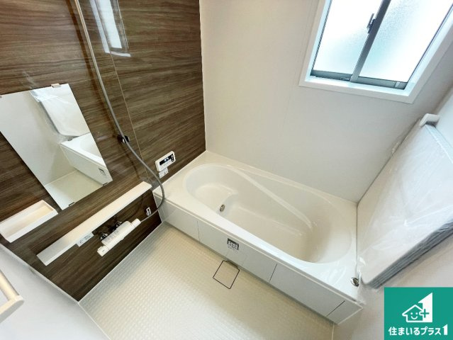 伊丹市荻野　第2期　新築一戸建ての浴室|足をゆったり伸ばして寛げる浴槽です。窓が設けられていますので差し込む光が明るく穏やかな雰囲気にしてくれます♪浴室乾燥機も設置しているので、雨の日の洗濯物も安心です♪