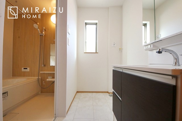 【洗面所】 | 洗濯機置き場と脱衣スペースもしっかりと確保されている洗面室、洗面コーナーは、窓から陽も差し明るく開放的な造りです。家事導線も良いので洗濯物やお湯はりもストレスフリーに毎日家事を楽しめそうです。
