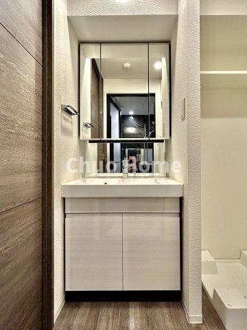 ミルーナヒルズ亀有の独立洗面台|【洗面化粧台】洗面化粧台には三面鏡を採用。身だしなみを整えやすい事はもちろんですが、鏡の後ろに収納スペースを設ける事により、散らかりやすい洗面スペースをすっきりさせる事が出来るのも嬉しいですね