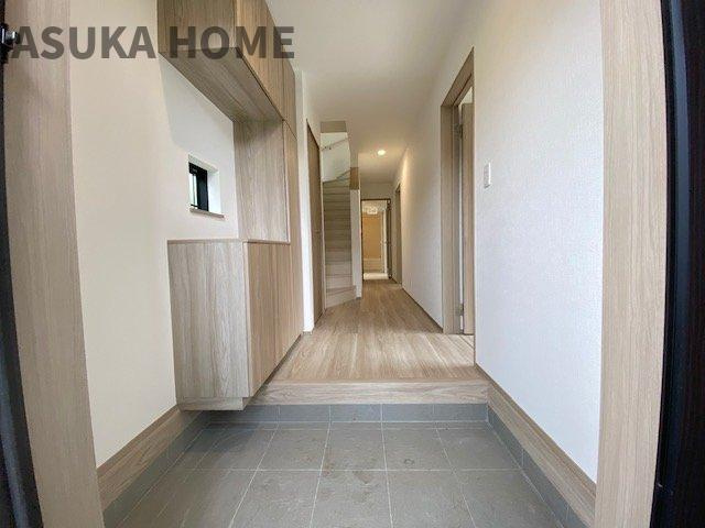 旭区今宿１丁目戸建ての玄関|白と木目調を基調とした明るい印象の玄関です。シューズクロークは鍵や写真が置けて利便性も◎