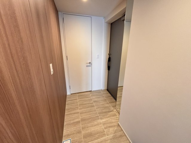 【品格漂う玄関アプローチ】木目調のアクセントウォールとタイル貼りの床が上質な空間を演出。姿見付きで外出前の身だしなみチェックもスムーズです。廊下からリビングまでフラットで開放的な動線が続きます。