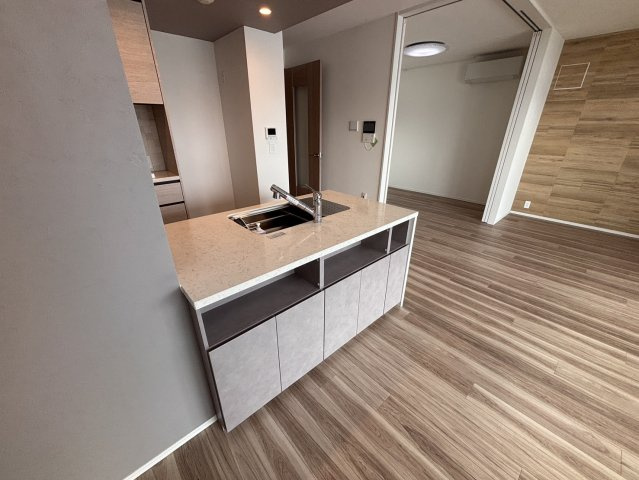 【会話が弾む対面式キッチン】料理をしながらリビングの家族や、窓の外に広がる運河の景色を楽しめるオープン設計です。高級感のある天板や充実の収納を備え、機能美と暮らしやすさを両立しています。