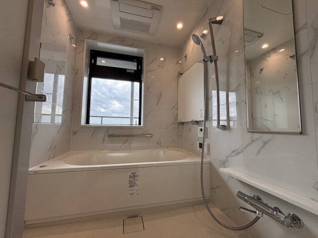 【心整う至福のビューバス】窓から運河の煌めきを望む、贅沢なバスタイムを実現。大理石調のパネルが高級感を演出し、浴室乾燥機などの機能も充実。都会の喧騒を忘れ、景色に癒やされる特別なリラックス空間です。