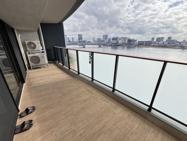 【開放感溢れるリバーサイドバルコニー】奥行きがあり、椅子を置いて寛げる広さを確保。南東向きで陽当たりも良く、目の前に広がる晴海運河とレインボーブリッジのパノラマビューを独占できる特等席です。