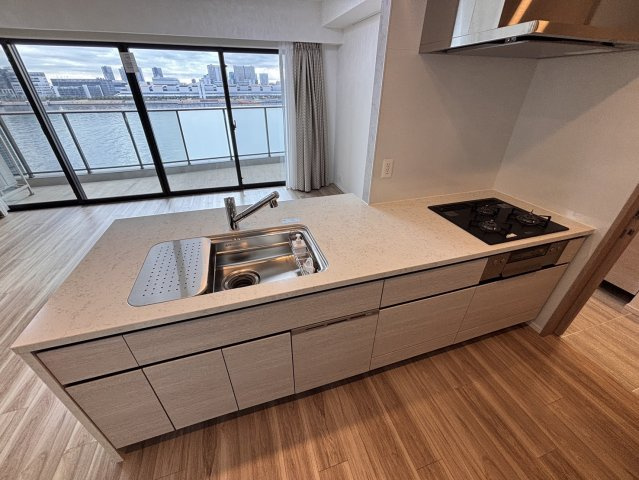 【景色を愉しむ対面キッチン】お料理中も運河のパノラマビューを堪能できる贅沢な設計。開放的なオープンタイプでリビングとの一体感もあり、ご家族やゲストとの会話を楽しみながら家事時間を過ごせます。