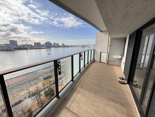 【開放感溢れるリバーサイドバルコニー】奥行きがあり、椅子を置いて寛げる広さを確保。南東向きで陽当たりも良く、目の前に広がる晴海運河とレインボーブリッジのパノラマビューを独占できる特等席です。