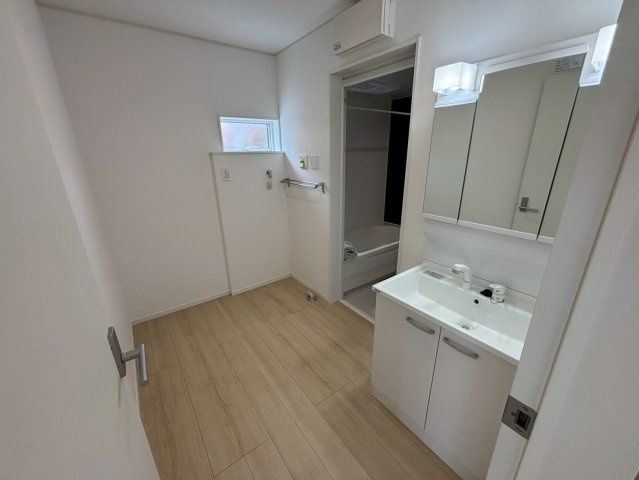 明和1丁目　新築戸建ての洗面所|ゆとりのある洗面脱衣所です。三面鏡洗面化粧台です。