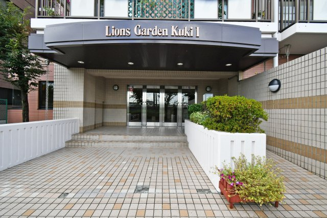 ライオンズガーデン久喜壱番館のエントランス|重厚感あるエントランスは住まいの第一印象を高める大切な空間。館名サインが映える設計で、来客時にも安心感を与えます。段差が少なく出入りしやすい動線と清潔に保たれた共用部から、管理体制の良さが伝わります。