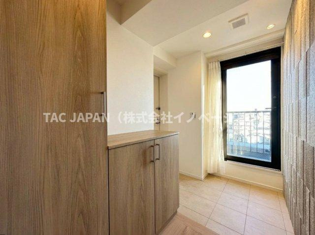 ライオンズマンション東日暮里第2の玄関|ルーフバルコニーの扉から明るい日差しが注ぐ開放的な玄関。大きなシューズボックスを備えたゆとりある玄関スペースはベビーカーやぱぱさんのゴルフバックを置いても日頃からスッキリお使いいただけます。