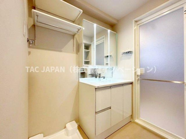 ライオンズマンション東日暮里第2の洗面所|大型の洗濯機を置いても余裕が感じられる脱衣スペースにはお洒落な洗面ユニットを制作。着替えやタオル、洗剤の買い置きなどリネン庫の使い方はお客様しだい。