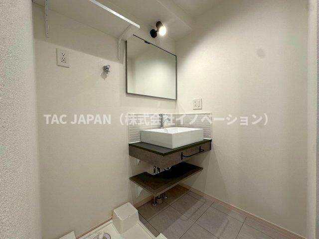 メゾン・ド・ヴィレ日本橋中洲の洗面所|【Powder room】
大型の洗濯機を置いても余裕が感じられる脱衣スペースには、つなぎ目が無くお手入れが楽なシームレスタイプの洗面ボール（棚付き）を造作しています。