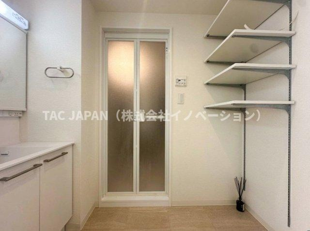 ダイアパレス西新井大師の洗面所|大型の洗濯機を置いても余裕が感じられる脱衣スペースにはお洒落な洗面ユニットを制作。着替えやタオル、洗剤の買い置きなどリネン庫の使い方はお客様しだい。