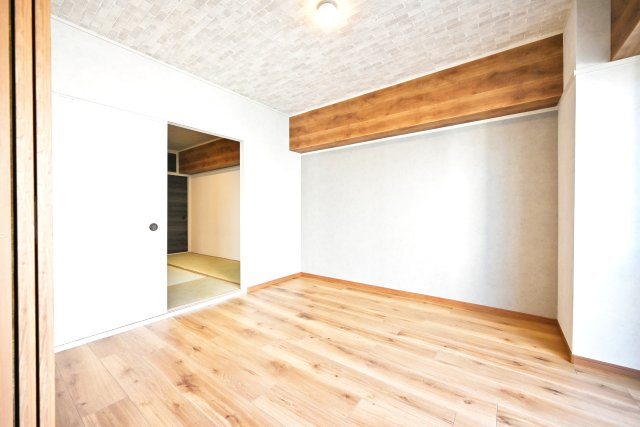 ハイム北野の洋室|リビング横の洋室約5.2帖。バルコニーに面した大きな窓から日差しが差し込むため、明るいお部屋になっていますね。