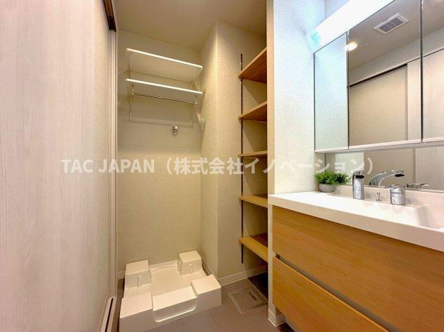 ルジェンテ南大塚の洗面所|大型の洗濯機を置いても余裕が感じられる脱衣スペースにはお洒落な洗面ユニットを制作。着替えやタオル、洗剤の買い置きなどリネン庫の使い方はお客様しだいです。