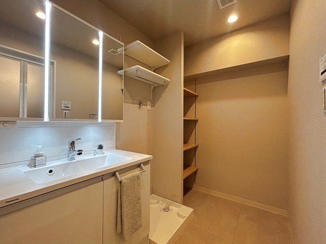 茨木南春日丘プライムタウンB棟の独立洗面台|収納棚があるから、バスタイムの準備もスムーズ。家族みんなが使いやすい洗面スペースに。暮らしやすさを感じられる工夫が詰まっています。