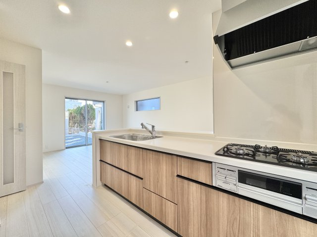 磐田市赤池　4期　1号棟のキッチン|木目調のデザインがやさしい印象の対面式キッチンです。リビング・ダイニングを見渡しながら料理ができ、家族との会話も弾みます！