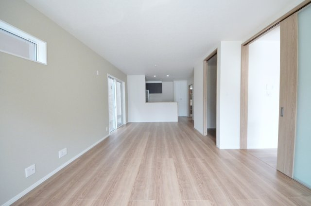 宮島口西三丁目の居間・リビング|東南向きの広く明るいリビング空間。オープンタイプの対面式キッチンでリビングが隅まで見渡せます。キッチンにいながら小さなお子様にも目が届き安心です。