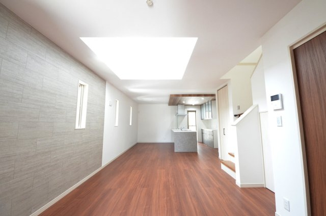 上安二丁目の居間・リビング|東南向きで窓の多いリビング空間。オープンタイプの対面式キッチンでリビングが隅まで見渡せます。キッチンにいながら小さなお子様にも目が届き安心です。