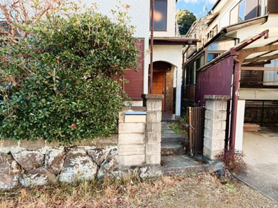 【玄関】 | 【湯河原町鍛冶屋】吹抜けがもたらす明るく開放的な室内 | 石積みの外構に守られたプライバシー感ある入口。落ち着いた住宅街で、静かな暮らしが叶います。