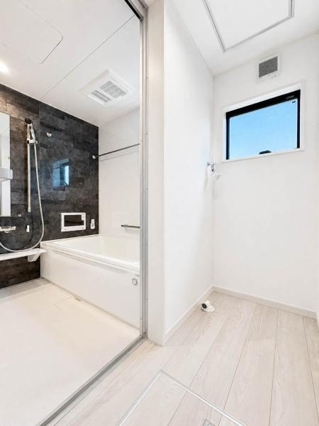 横浜市南区清水ケ丘の新築一戸建の独立洗面台|浴室と隣接した洗濯機置場。窓から自然光が入り、白を基調とした明るく清潔感のある空間です。水まわりがまとまっているため、洗濯などの家事動線もスムーズで、毎日の使い勝手にも配慮されています。