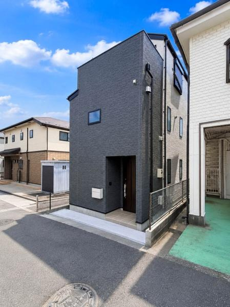 横浜市南区清水ケ丘の新築一戸建の前面道路含む現地写真|角度を変えて見ることで、建物の奥行きや外壁デザインがより際立つ一枚。落ち着いた住宅街に馴染む洗練された外観で、新築ならではの清潔感と上質さを感じられます。
