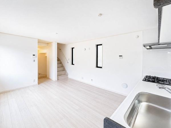 横浜市南区清水ケ丘の新築一戸建の居間・リビング|キッチン側からLDK全体を見渡せる開放感のある一枚。白を基調にした明るい室内は、家具を配置しても圧迫感が出にくく、すっきりとした暮らしをイメージしやすい空間です。動線も取りやすく、使い勝手も良好です。