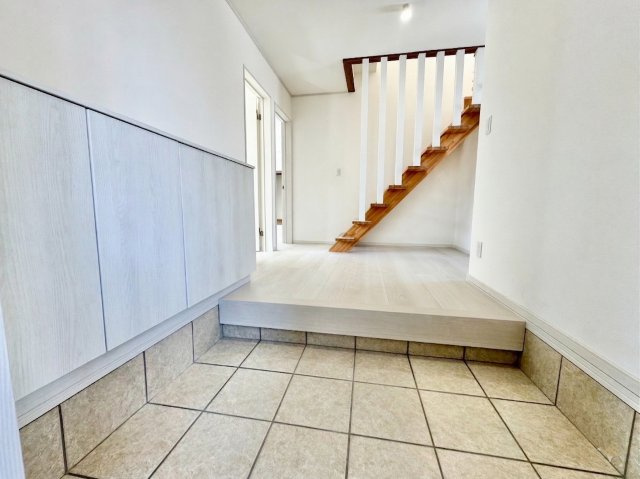 【売主物件】美原5丁目で叶う、水回りもピカピカのリフォーム住宅◎の玄関|白で統一された明るい玄関ホール。お洒落な階段が目を引く。