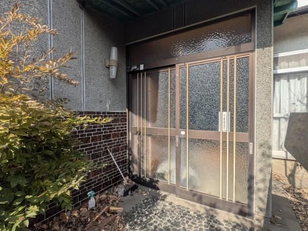 千歳　中古の玄関|玄関部分には落ち着いた色合いのタイルとすりガラスが使用されています。屋根付きで雨の日も安心です。周囲には植物もあり自然を感じられる空間となっています。