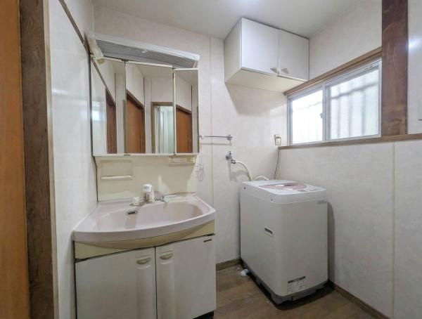 千歳　中古の独立洗面台|洗面台と洗濯機が配置され使い勝手の良い洗面所です。収納スペースも確保されており整理整頓しやすくなっています。窓があるため換気もしやすい洗面空間です。明るく清潔感のある内装が特徴です。