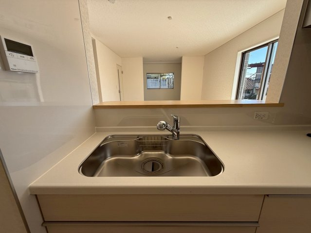 クレイドルガーデン糸満市座波 第２・３号棟のキッチン|浄水器付きキッチンの流し台／リビングの眺め