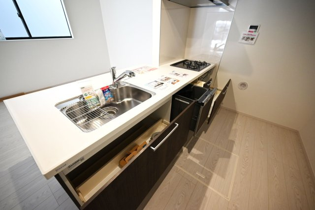 テラシエ松ケ丘2丁目新築一戸建て│4LDK+駐車駐輪のキッチン|キッチン天板下いっぱいに収納庫を設けてあります。シンクした収納庫にはナイフホルダーも標準搭載。食器洗い乾燥機や浄水器一体型水栓も標準仕様のユニットが導入されています。