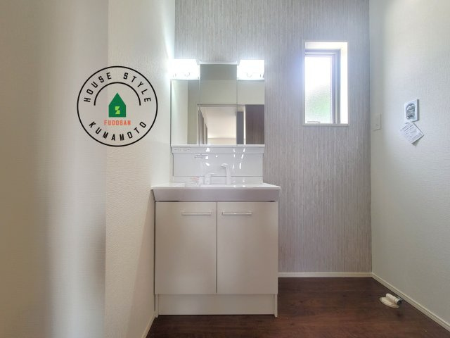 熊本市西区野中2丁目第1-2棟(1号棟)の内観：施工例|毎日使うものだから清潔な空間を保ちたい水回り。洗面にはそんな願いを解消させてくれる収納アイデアが満載です。三面鏡の裏側にはキャビネットが現れ小物から背の高い物まで収納できます。