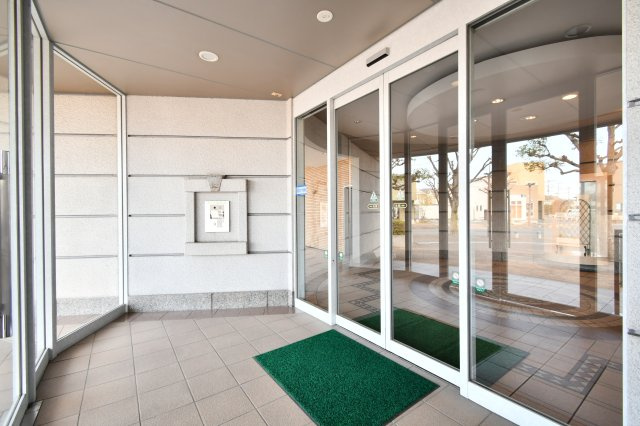 ルネ・グランテラスのエントランス|重厚感あるタイル貼りのアプローチが、住まう人を優雅に迎えるエントランス。スロープ併設でベビーカーや車椅子での移動もスムーズです。管理の行き届いた清潔感あふれる佇まいが、日々の安心と誇りを支えます。