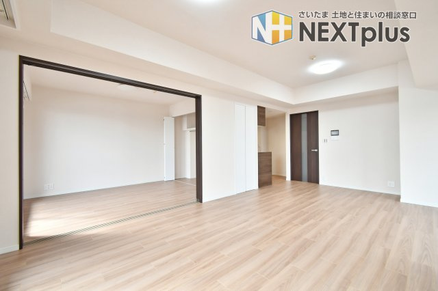 ライオンズヴィアーレ大宮の居間・リビング|隣接する洋室の扉を開放すれば更に広々とした大空間に。家族構成や用途に合わせてリビングの一部として一体活用できる柔軟さが魅力。リフォームで和室から洋室へ変更されており、モダンで統一感のある住まいを実現。