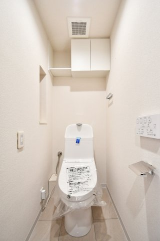 ライオンズヴィアーレ大宮のトイレ|令和7年3月交換済みの温水洗浄便座付きトイレ 。白を基調とした清潔感溢れる空間に、便利な吊戸棚も完備しています。フロアタイルやクロスも一新され、毎日の生活を心地よく支えます。