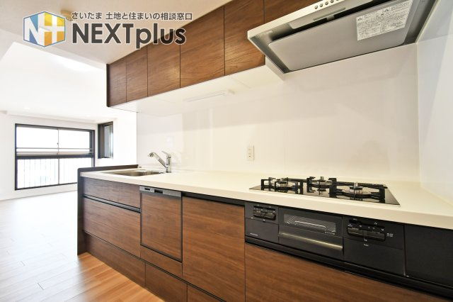 ライオンズヴィアーレ大宮のキッチン|三口コンロとワイドな調理スペースで、料理がより楽しく効率的に。木目調デザインが室内の雰囲気に調和します。スライド収納は奥の物まで取り出しやすく、増えがちな調理器具もスッキリと収まる高い収納力。