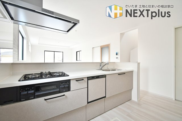 蓮田市馬込11期のキッチン|キッチン横に便利なシェアクローゼットを完備。パントリーや日用品収納として活用でき、散らかりがちなLDKを常に美しく保てます。食洗機付きの対面キッチンで、家事効率と家族の会話が弾む設計です。