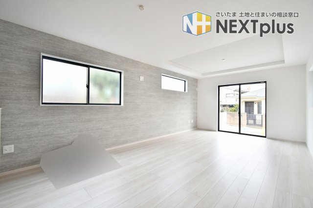 蓮田市馬込11期の居間・リビング|質感豊かなアクセントクロスが目を引く、お洒落なリビングダイニング。南向きの窓から注ぐ陽光が、明るく心地よい家族の時間を演出します。ZEH水準の断熱性能で、夏涼しく冬暖かい、健康的な住まいを実現します。