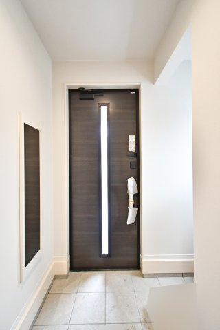 蓮田市馬込11期の玄関|「ただいま」が誇らしくなる、光と質感の玄関。重厚感あるドアから漏れる光と、清潔感溢れるタイルが家族を優しく迎えます。機能性と美しさを両立したデザインは、まさに邸宅の顔に相応しい空間です。