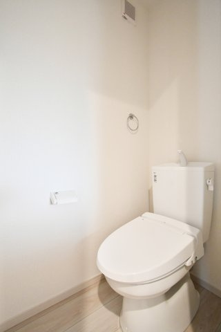 蓮田市馬込11期のトイレ|清潔感溢れる白を基調とした心地よいレストルーム。毎日使う場所だからこそ、掃除のしやすい設備と温かな木目調のフロアを採用しました。プライベートな時間を快適に過ごせる、シンプルで飽きのこない空間です。