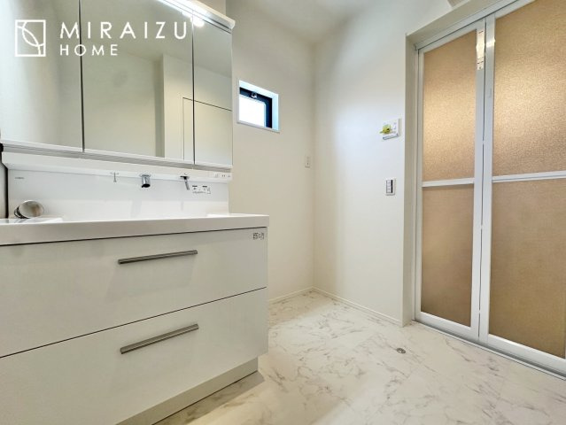 【洗面所】 | 洗濯機置き場と脱衣スペースもしっかりと確保されている洗面室、洗面コーナーは、窓から陽も差し明るく開放的な造りです。家事導線も良いので洗濯物やお湯はりもストレスフリーに毎日家事を楽しめそうです。
