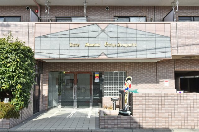 ライオンズマンション大宮浅間町|植栽の緑が美しく整えられた、品格漂うアプローチです。落ち着いた色調のタイル貼りの外観が、住まう人を優雅に迎え入れます。スロープが設置されており、ベビーカー等の移動もスムーズです。