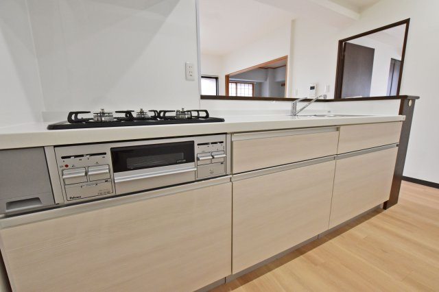リーガル塚本第6のキッチン|白色を基調とした清潔感あふれるシステムキッチン。お鍋やフライパンのような大きな調理器具も楽々収納できます。