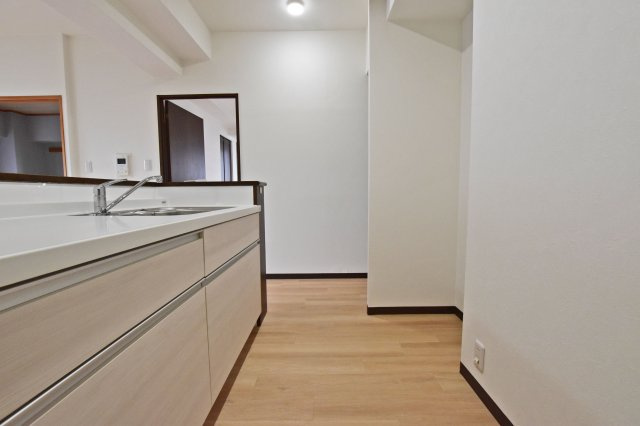 リーガル塚本第6のキッチン|キッチン奥から撮影した写真です。キッチンはオープンタイプの対面式なのでお料理中でも家族との会話を楽しめます。