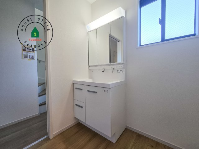 福岡市南区鶴田4丁目第5-3棟（2号棟）の内観：施工例|毎日使うものだから清潔な空間を保ちたい水回り。洗面にはそんな願いを解消させてくれる収納アイデアが満載です。三面鏡の裏側にはキャビネットが現れ小物から背の高い物まで収納できます。