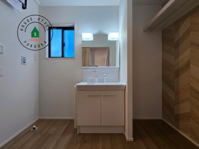 福岡市南区老司1丁目第8-3棟（1号棟）の内観：施工例|毎日使うものだから清潔な空間を保ちたい水回り。洗面にはそんな願いを解消させてくれる収納アイデアが満載です。三面鏡の裏側にはキャビネットが現れ小物から背の高い物まで収納できます。